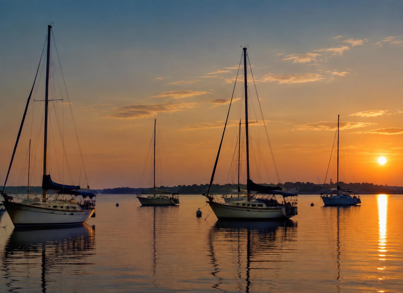 Sailboats anchored in a calm Gulf Coast harbor at dawn